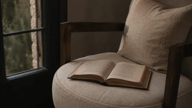 Libro aperto su una poltrona accanto alla finestra